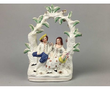 TWO STAFFORDSHIRE MARRIAGE GROUPS,30.5cm high, along with another group modelled with a couple flanking a clock face, and two