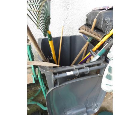 A BLACK WASTE BIN WITH CONTENTS OF GARDENING TOOLS.
