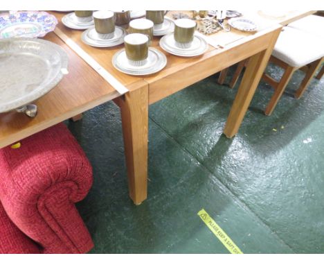 A LIGHT OAK EXTENDING DINING TABLE WITH A SET OF FOUR CHAIRS WITH UPHOLSTERED SEAT PADS.