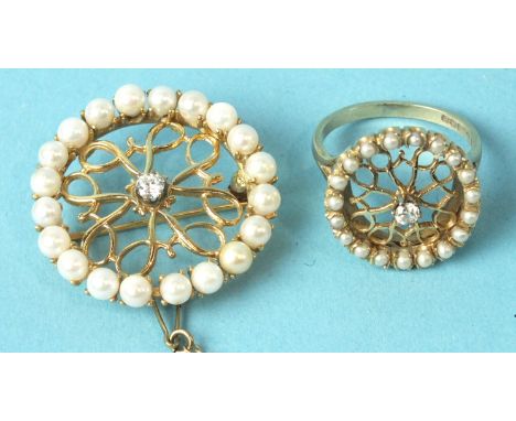 A modern 14ct gold brooch of circular form, the border set cultured pearls around a pierced open-work panel centred with a br