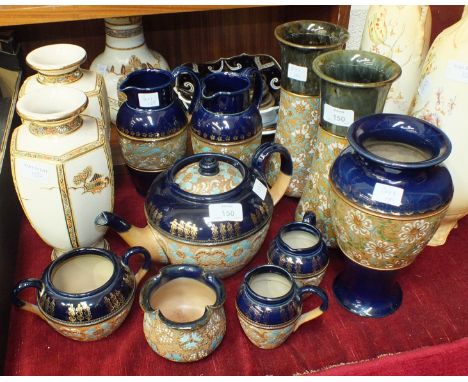 An Edwardian Royal Doulton stoneware four-piece tea service, the upper body with gilt decoration, on a blue ground, above tur