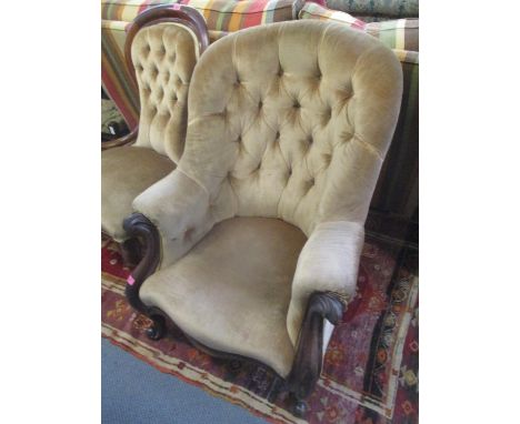 A Victorian mahogany button back armchair having scroll shaped arms and cabriole front legs 