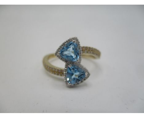 A Tivon 18ct yellow gold blue topaz and diamond crossover ring, diamond approximately 0.3ct, topaz approx 1.13ct 