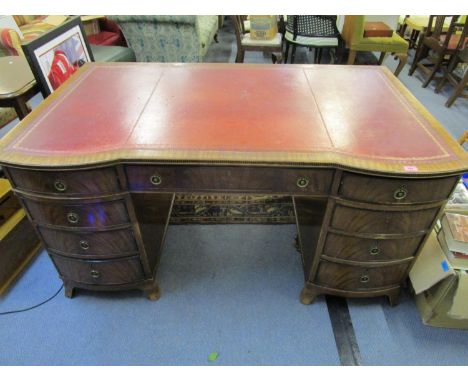 A Maples &amp; Co reproduction mahogany twin pedestal writing desk, serpentine front with three frieze drawers below a fluted