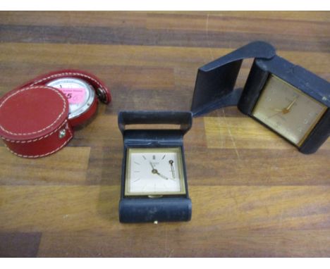 Two looping blue leather travelling alarm clocks and a quartz OKA travelling clock