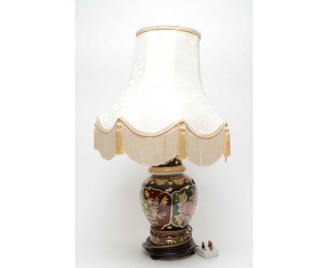 A Chinese ceramic table lamp, decorated with alternating panels of bamboo and flowers, on stained wood stepped circular base,