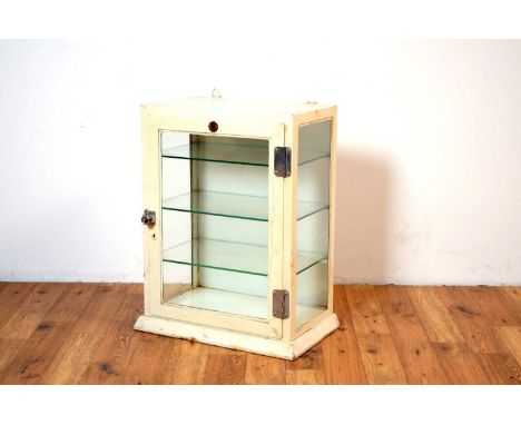 A vintage glazed dentists cabinet by Allen &amp; Hanbury Ltd, cream painted with chrome hinges and door latch, glass shelves 