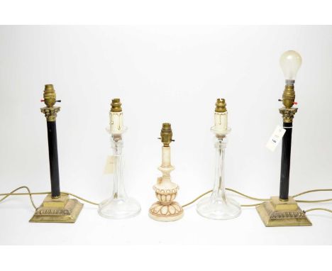 A pair of early 20th Century glass table lamps, with faux candle wax and brass mounts, each 34.5cms high; together with a pai