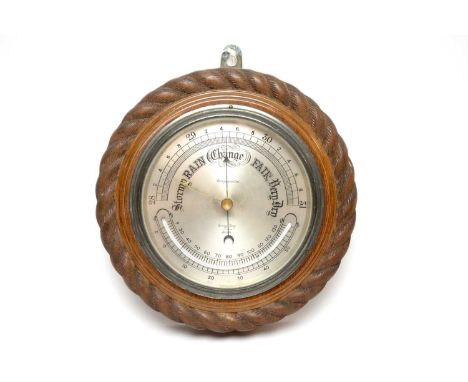 A vintage wall barometer, by Army &amp; Navy Stores Ltd, London, the carved oak case 26cms diameter.