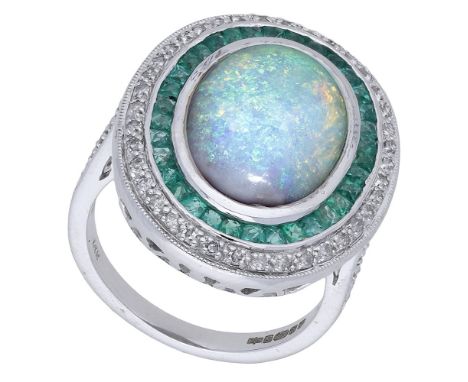 A 14ct white gold opal, emerald, and diamond cluster ring, the oval opal cabochon collet-set within a surround of calibré-cut