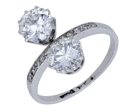 A two stone diamond ring, the two principal brilliant-cut diamonds spaced by a millegrain-set row of single-cut diamonds, sha