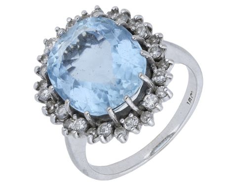 An aquamarine and diamond cluster ring, the oval mixed-cut aquamarine claw set within a cluster surround of alternate larger 