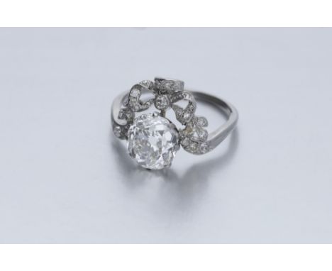 An early 20th century diamond ring, the cushion-cut diamond, weighing 3.32 carats, within a garland setting designed as a bow