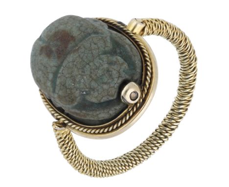 A scarab ring, the blue ceramic scarab with indistinct hieroglyphic figures to the underside, the hinged mount with ropetwist