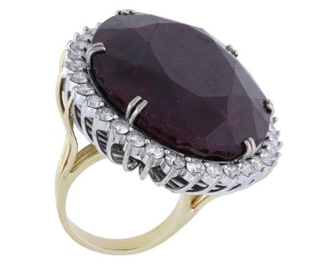 A ruby and diamond cluster ring, the large oval mixed-cut ruby claw-set within a surround of brilliant-cut diamonds, the trif