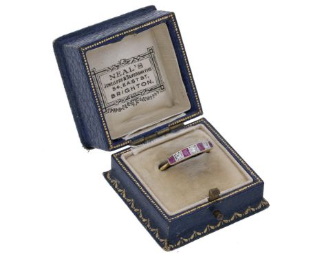 An early 20th century ruby and diamond ring, set with an alternating row of step-cut rubies and single-cut diamonds, mounted 