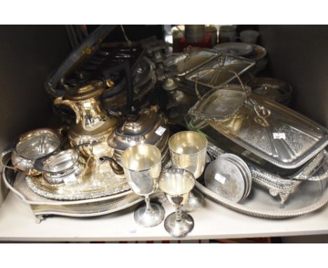An assortment of flat ware and cutlery, including plated ware, serving dishes, goblets and candlestick, tea and coffee pots e
