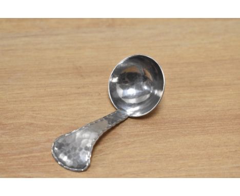 A Keswick school of industrial arts hammered stainless steel caddy spoon.