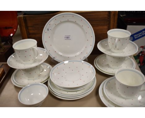 A selection of Susie Cooper cups and saucers, plates and sugar basin, having white ground with blue rim and red polka dots.