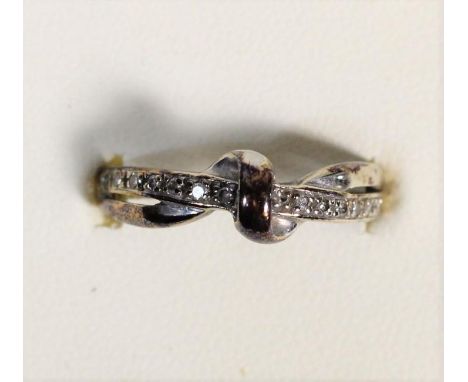 A 9ct white gold and diamond crossover ring, M, 2.2gm 