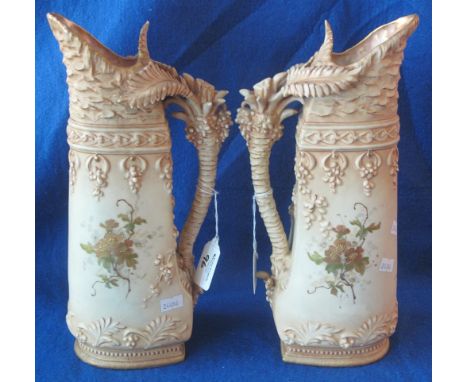 Pair of Austrian porcelain blushed ivory ground ewers with palm tree handles and gilded and painted floral decoration, the bo