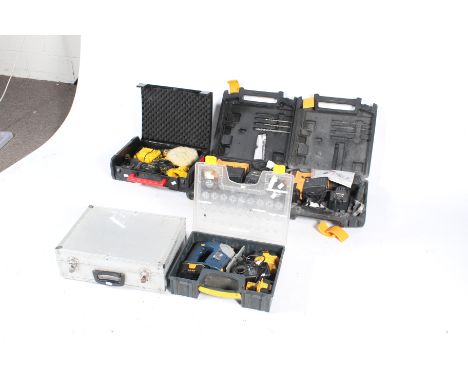 A collection of workshop power tools. Noting Dewalt drills, a Ryobi saw and others, in cases. 