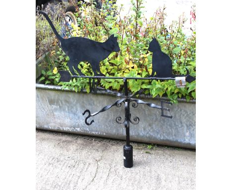 A metal weather vane in the form of a cat. With two cat figures to the top, turned spurs pointing North, East, South and West