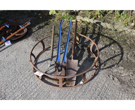 A collection of hand tools and a barb wire roller. Inclusing a sickle and spade etc, the wire roller is collapsable.