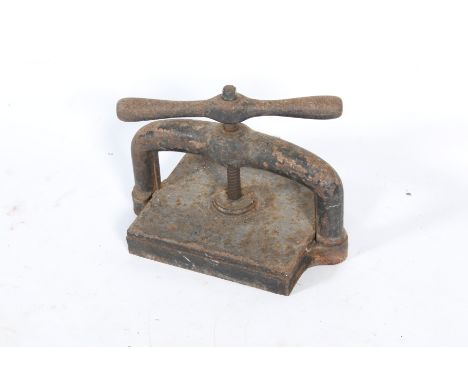 A heavy cast iron press. Square in shape with corkscrew type action and handle, W42cm x D25cm.