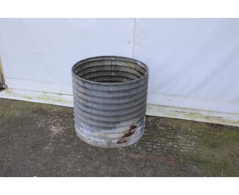 A circular corrugated metal water tank/planter. With facility to attach tap but not watertight, H60cm x diameter 65cm. 