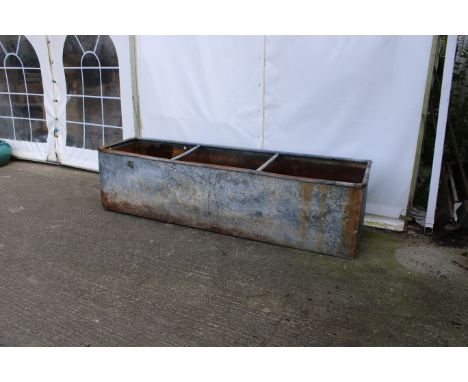 A large rectangular galvanised trough/planter. With loops for wall mounting and two central bracing bars, appears watertight,
