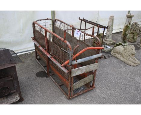 A metal sheep handling crush. With metal floor, wooden sides and rear gate, front is wooden panels.