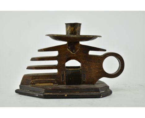 A 20th century Arts &amp; Crafts wooden and metal candlestick holder. The candle carved in the shape of a hand with a handle,