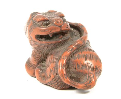 Japanese carved wooden netsuke, designed as a tiger, modelled seated on it's haunches, snarling, carved detailed fur, inlaid 