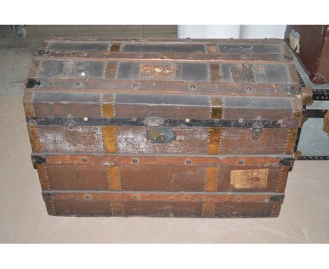 An early 20th Century wood and metal bound domed top travelling trunk.