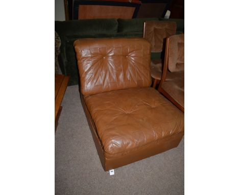 A modern brown leather easy chair, c.1980, with button back and seat, 71cms high.