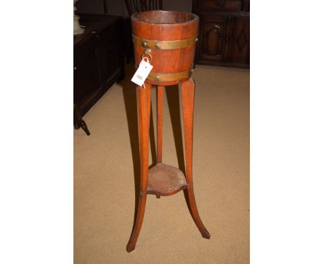 An R.A. Lister & Co. Ltd. early 20th Century oak brass bound planter on stand joined by undertier.
