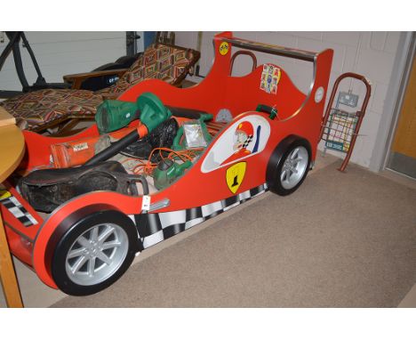 A child's Formula 1 style racing car single bed, with electric light fitting.