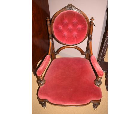 A Victorian walnut armchair, circular button upholstered back, arms and seat upholstered in red velour with turned legs raise