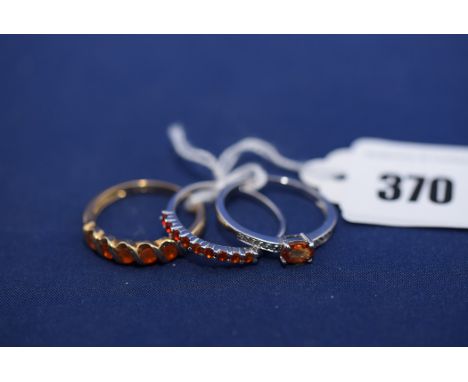 Three orange stone set rings, one with diamond shoulders, all in 9ct. gold shanks, ring sizes R/S.