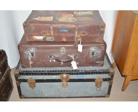 A leather suitcase by Revelation, with travel and cruise labels; a leather effect suitcase; and a travelling trunk with metal