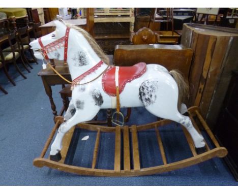 A LARGE PAINTED ROCKING HORSE, with red saddle and pine base