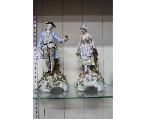 A PAIR OF CONTINENTAL FIGURAL CANDLESTICKS, modelled as lady and gentleman next to tree stump candle holder on naturalistic f