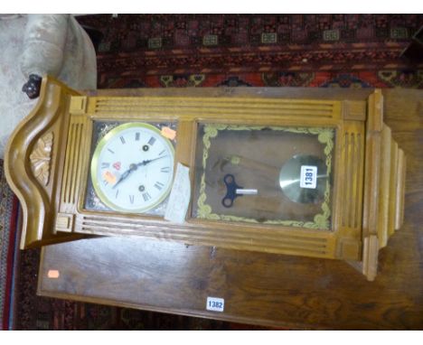 A MODERN OAK CASED WALL CLOCK (key and pendulum)