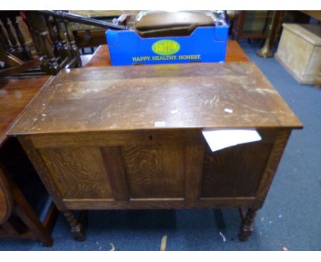 AN OAK TRIPLE PANEL BLANKET CHEST, raised on barley twist supports (key)