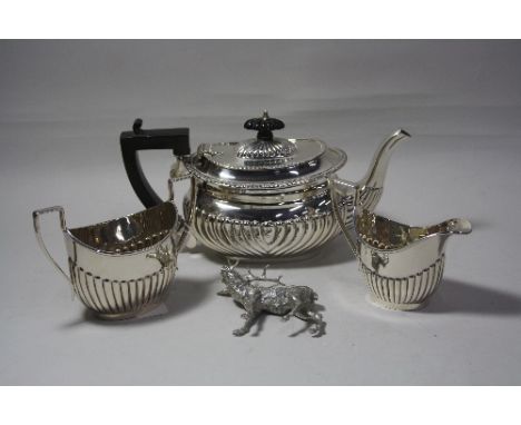 A SILVER HALF GADROONED TEAPOT, with ebonised handle and finial, Birmingham 1930, together with half reeded silver milk jug a