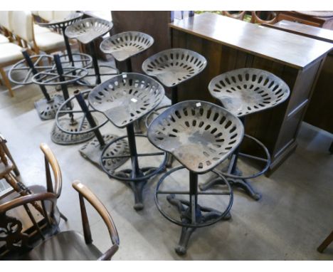 Ten cast iron tractor seat stools, a/f 