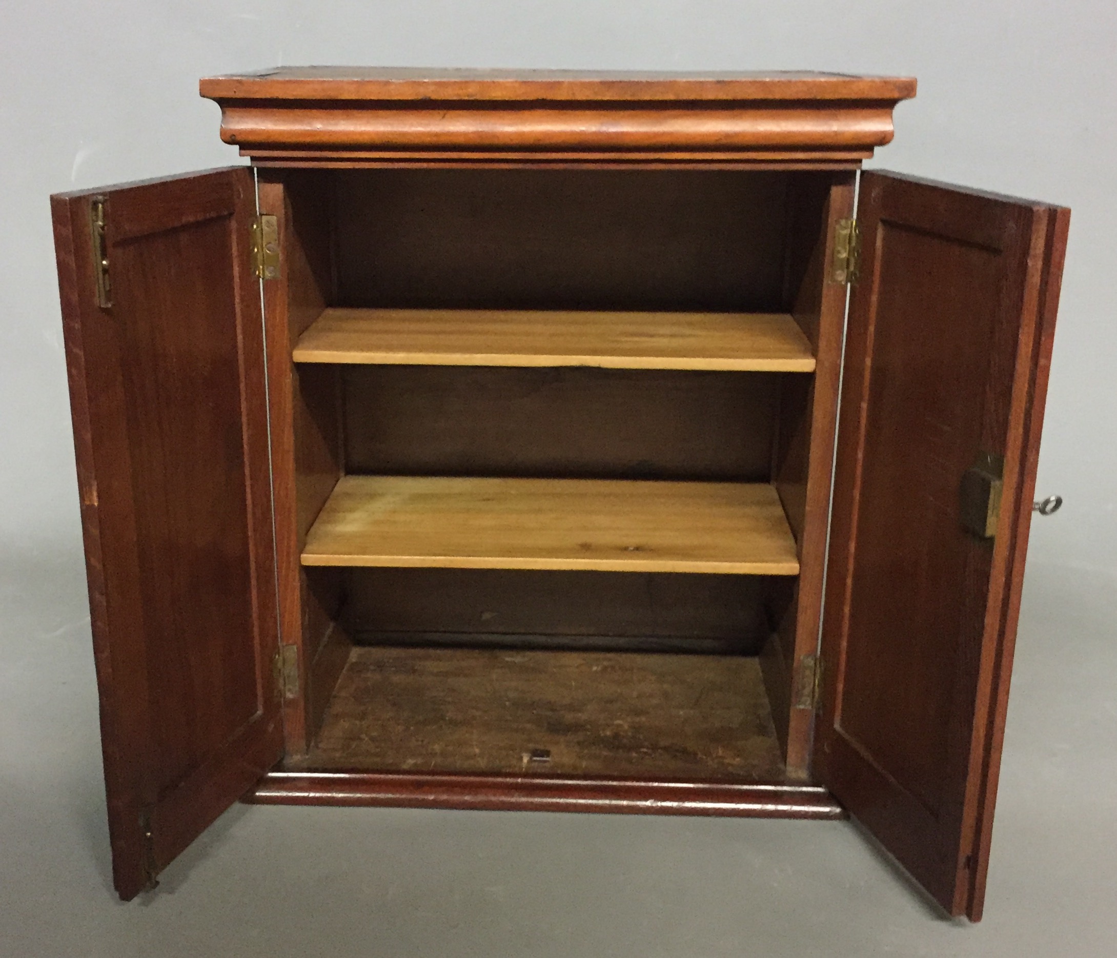 A MAHOGANY TABLE TOP CABINET With two panelled doors enclosing a ...