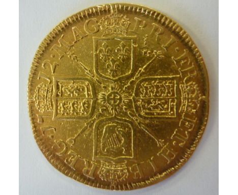 An early 18th century Queen Anne gold Guinea, the four union shields bordered by Latin legend and dated 1712, with milled edg