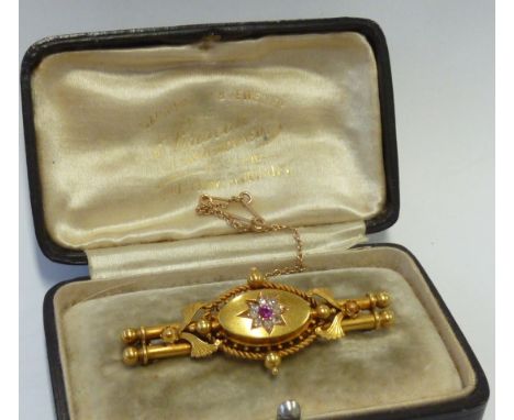 A 19th century 15-carat yellow gold Bar Brooch and Chain, the central red hand-cut stone (probably a ruby) surrounded by smal